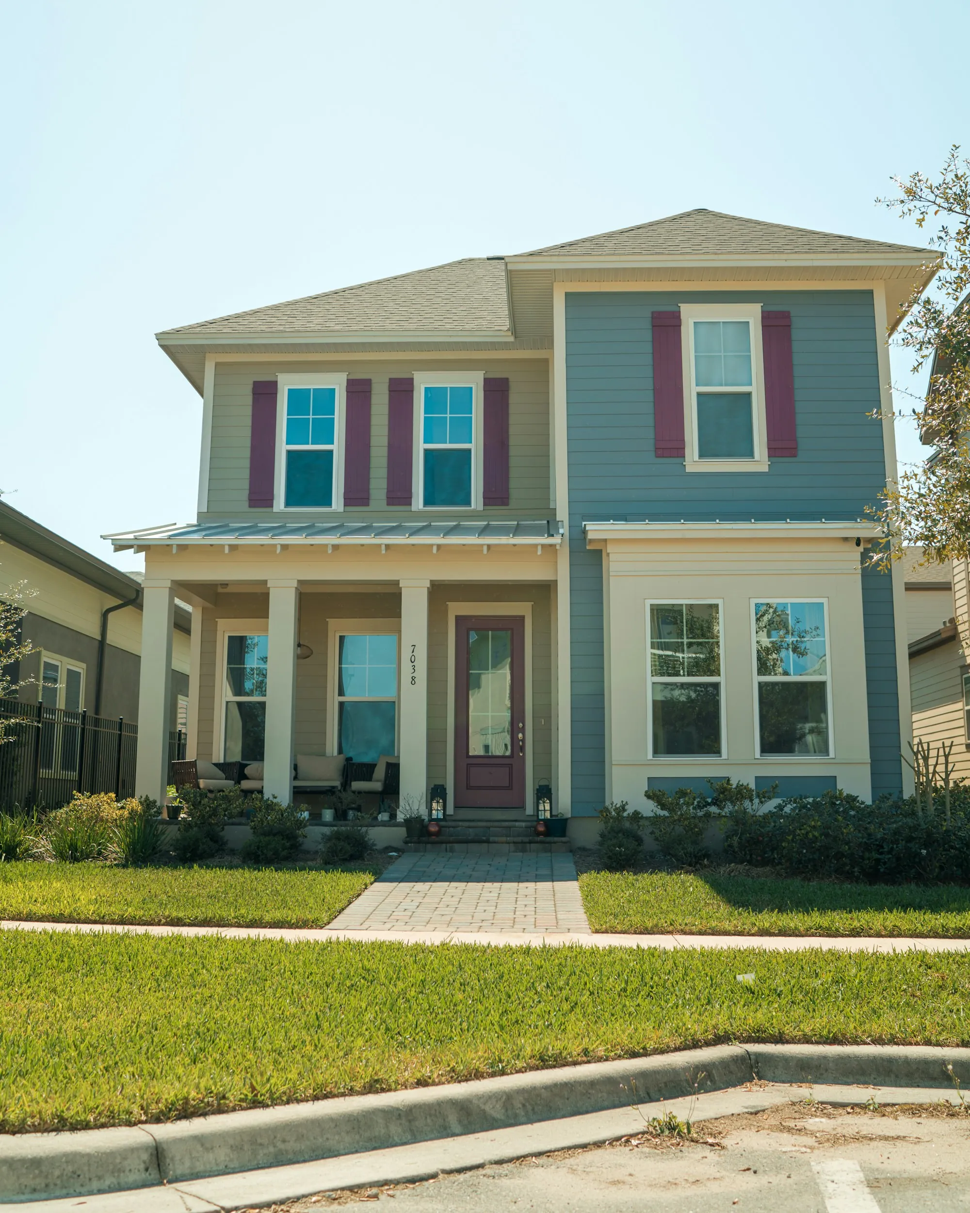 Two-story brick home with a contractor's work van parked in the driveway