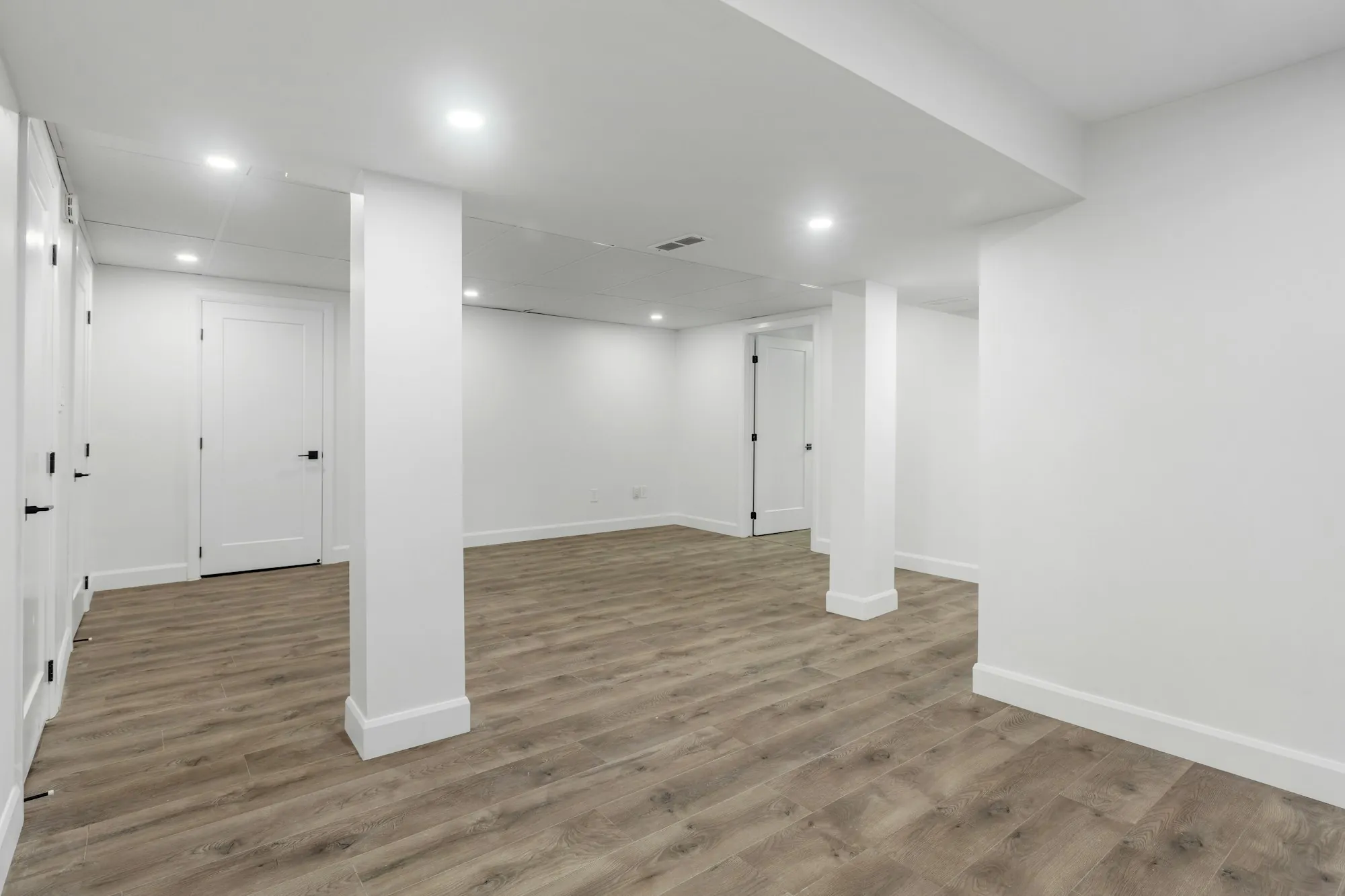 Finished basement with a sectional sofa, recessed lights and a home office nook