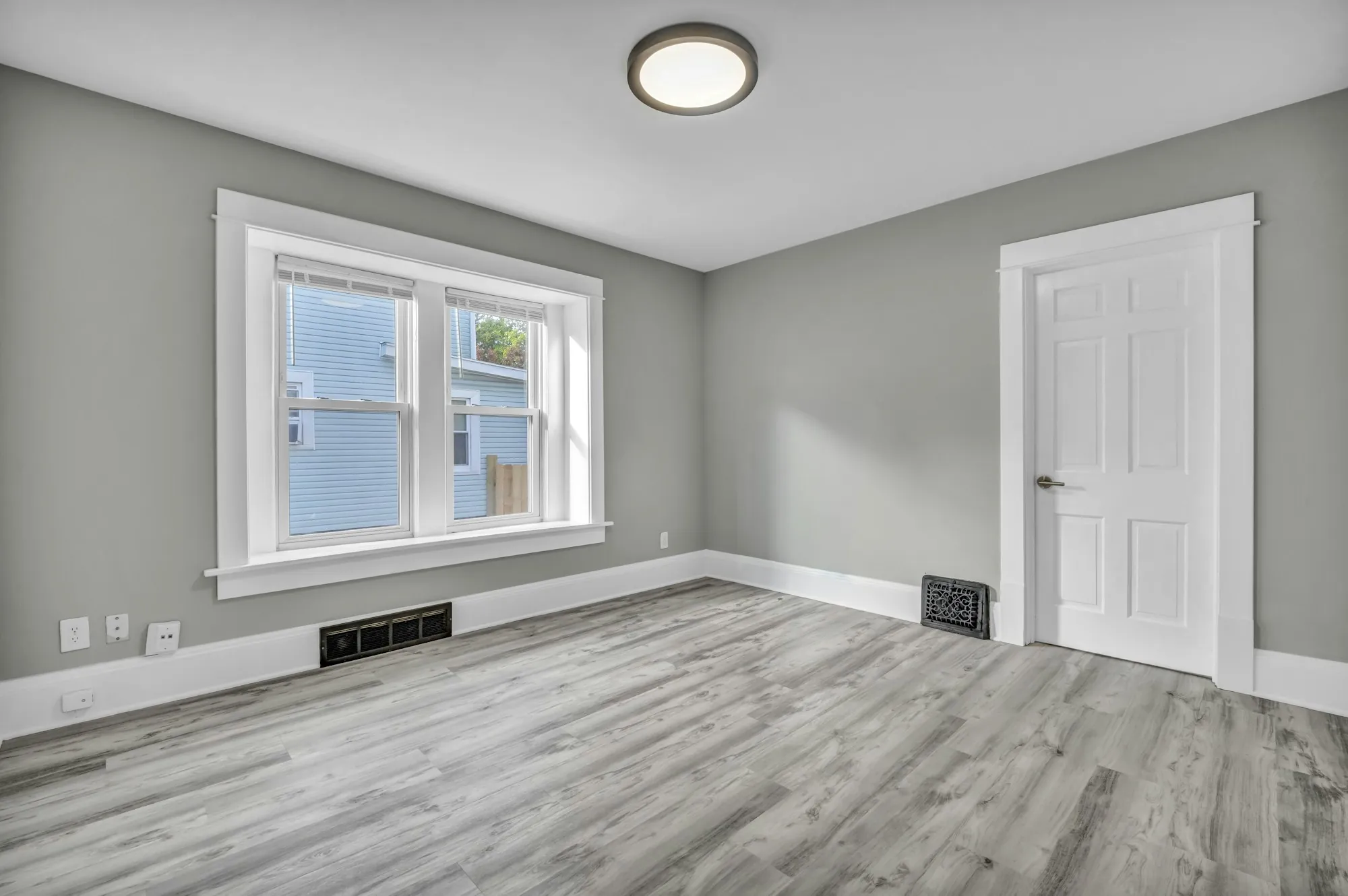 Freshly painted gray room with crisp white trim, door and window casings